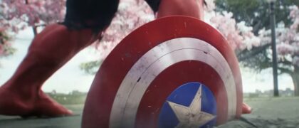 Captain America's shield smashed half way into concrete next to the legs of Red Hulk.